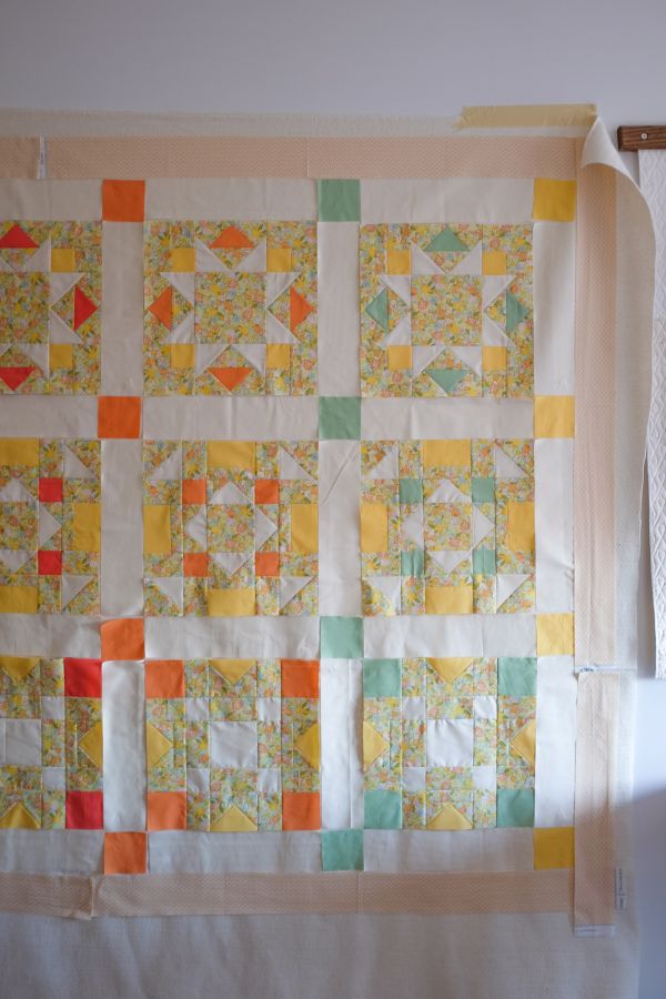 9 squares of quilting block laid out on a flat surface, ready to be connected